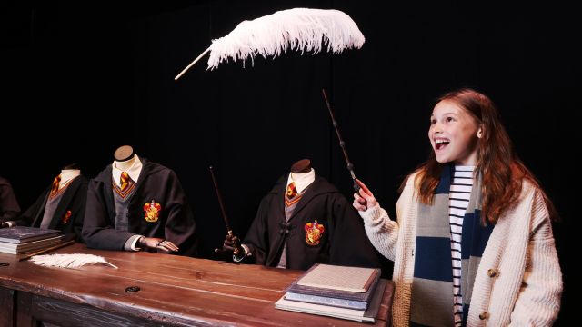 Wingardium leviosa! Cast spells at Discovering Hogwarts at the Warner Bros. Studio Tour. Image courtesy of Tinman Comms. A person uses a wand to cast a spell over a feather at the warner bros studio tour london.