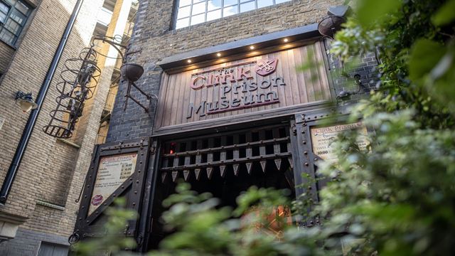 low angle photo taken outside Clink Prison Museum, showing the metal door gate entrance