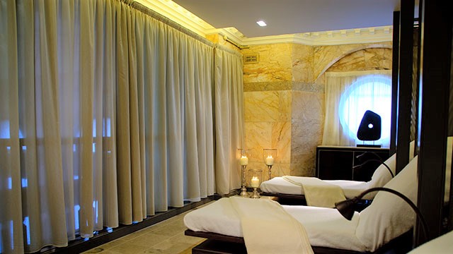 Unwind in the relaxation room in Sofitel SPA at Sofitel London St James © Red Letter Days. Image courtesy of Red Letter Days. A relaxation room in the spa with beds covered with towels and lit candles