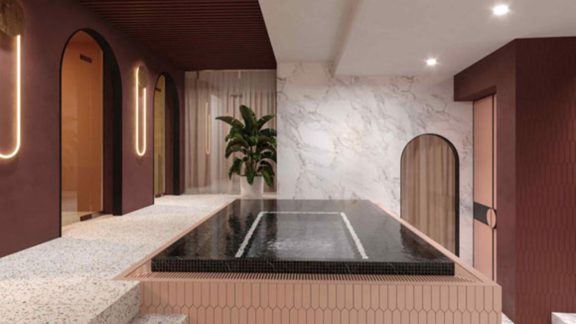Enjoy a luxury spa day at Euphoria Spa. Image courtesy of Red Letter Days. chic spa room with stone-pink walls and marble, curved top doors and lighting and a square pool