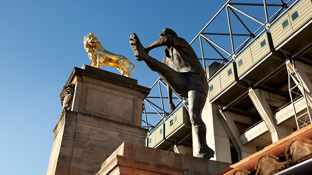 Twickenham Stadium © Getty Images A statue of a rugby player after kicking a ball, and a gold lion statue.