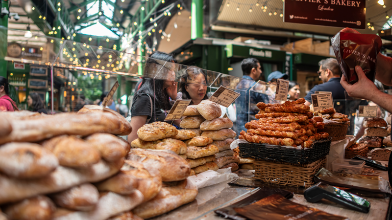 Hunt for fresh, locally sourced goods at Borough Market. Credit: London & Partners/Michael Barrow. Image courtesy of visitlondon.com. Stacks of freshly baked bread and goodies at a Borough Market stall