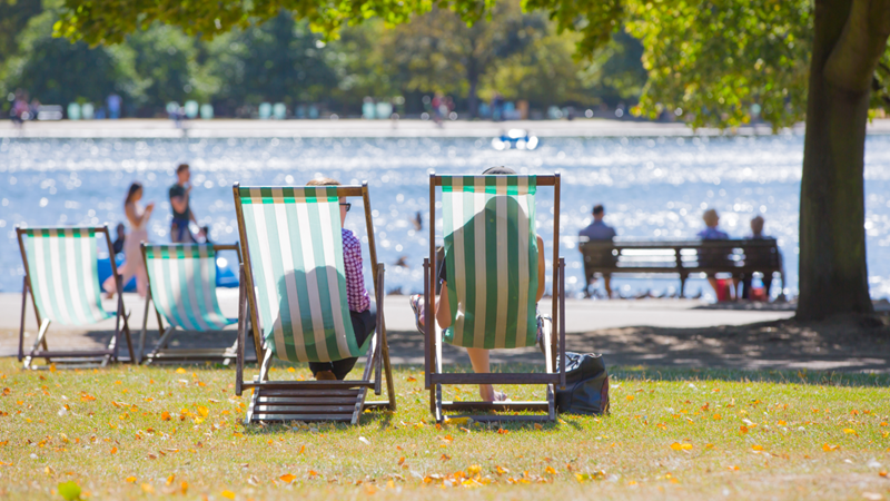Hyde Park in west London is a popular setting for some of the best films in the world. Credit: Shutterstock. Image courtesy of Shutterstock. Two people sat on striped deck chairs in front of the lake at Hyde Park