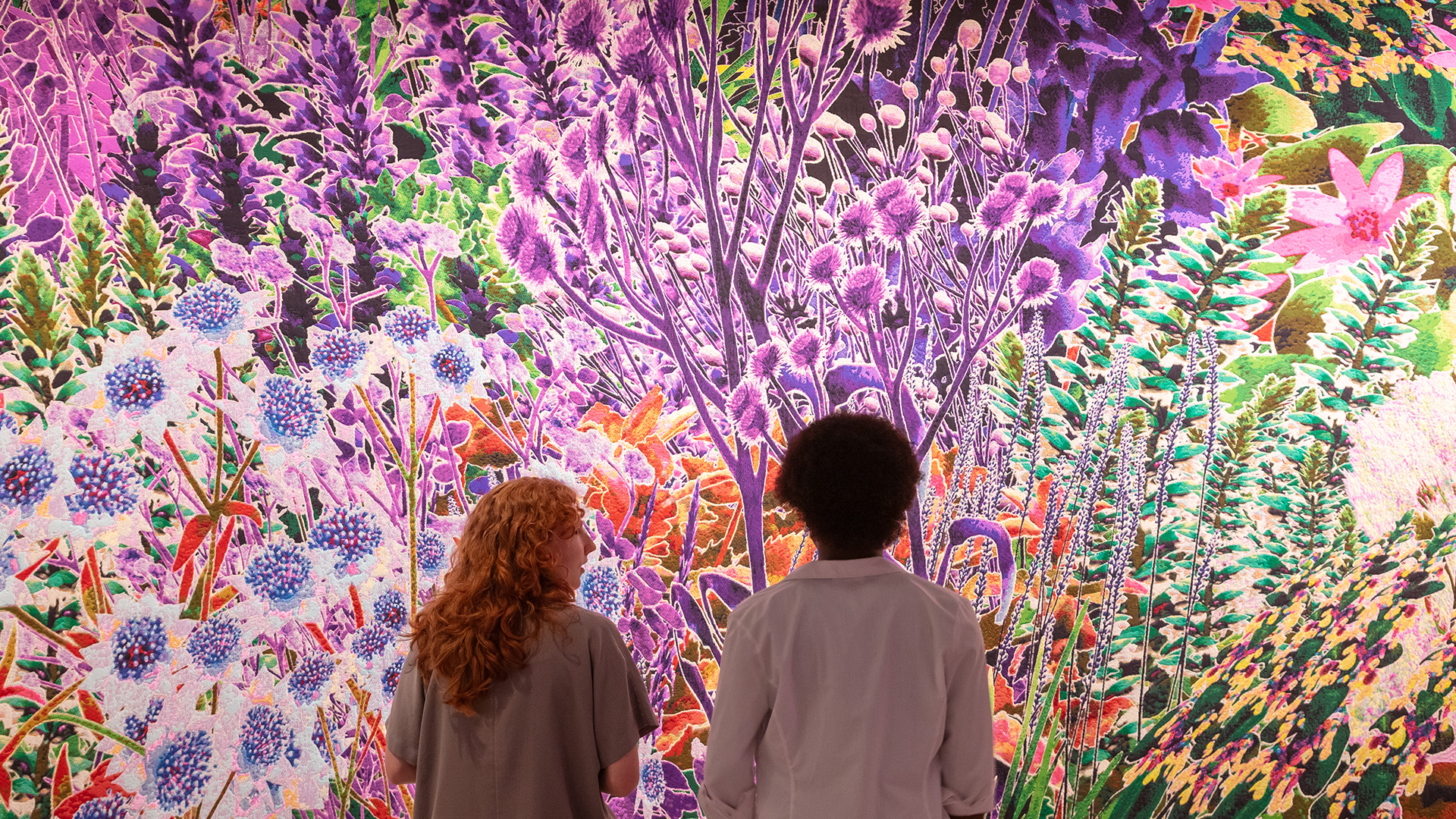 More than Human at the Design Museum. Image courtesy of Luke Hayes/Design Museum. A couple gaze at a vibrant floral artwork at More than Human at the Design Museum