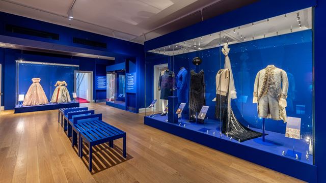 Exhibition room showcasing royal outfits at Kensington Palace.