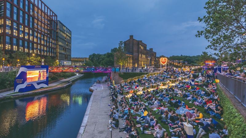 Catch a free screening at Screen on the Canal. Credit: John Sturrock. Image courtesy of Screen on the Canal. Crowds watching a film on the canal banks at night in King's Cross, London.