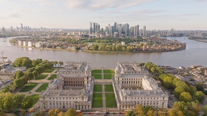Watch top live acts with a backdrop of the sunset over the Thames at Labyrinth on the Thames. Credit: Labyrinth on the Thames. Image courtesy of Labyrinth on the Thames. A birds-eye photo of the Old Royal Naval College with the City of London and Thames behind, the venue for the inaugural Labyrinth on the Thames festival