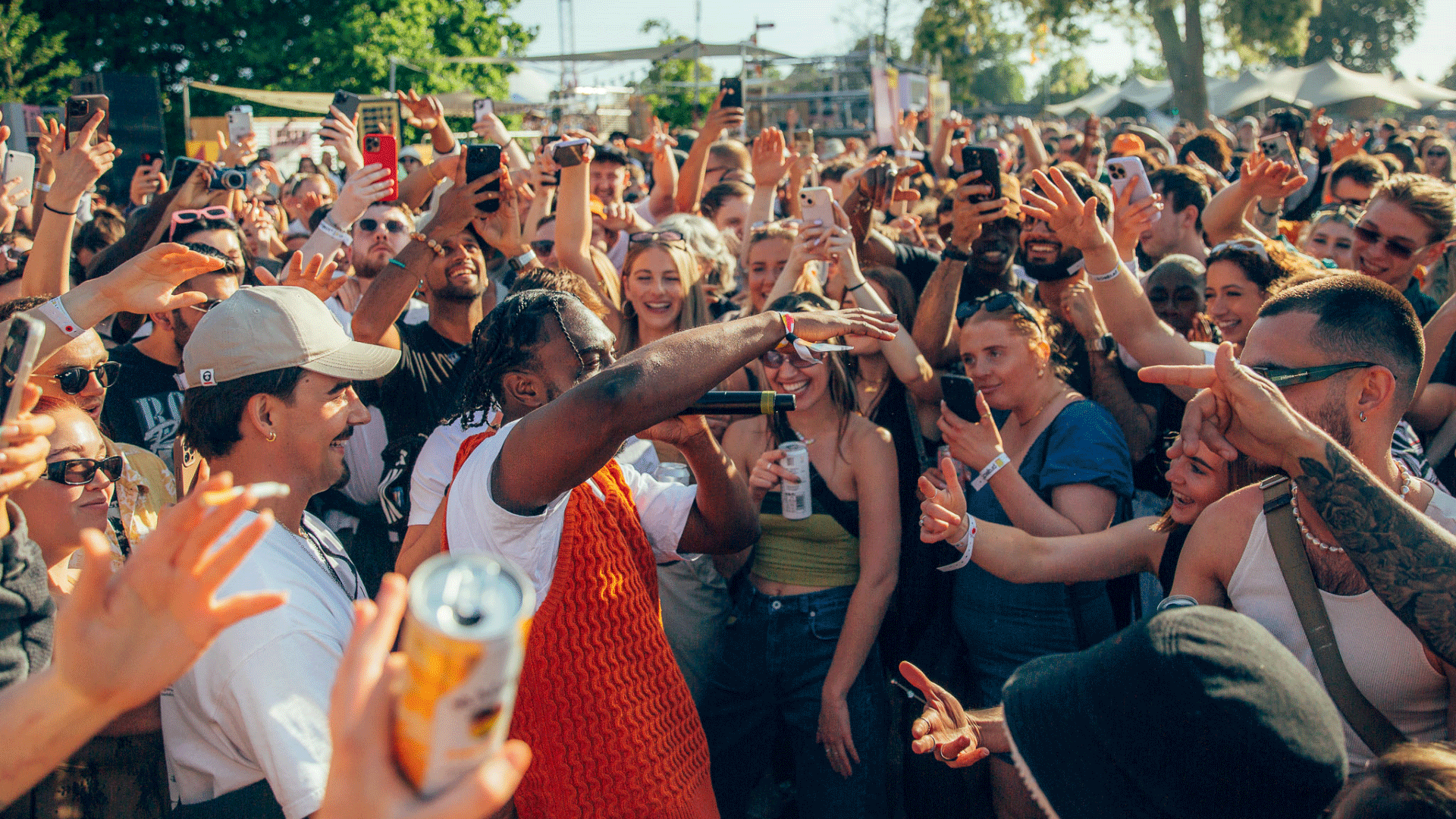 Artist performs in the crowd at Project 6. Credit: Amy Fern Photography. Crowds throwing their hands up in the air and singing along while the artist sings in the crowd