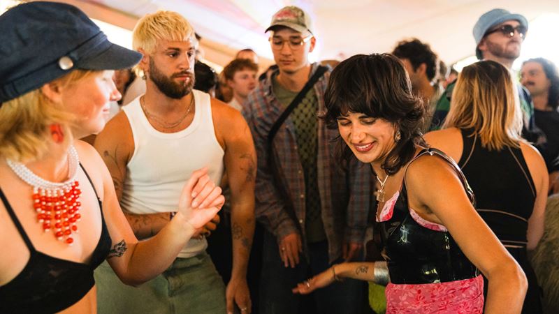 Take in the good vibes, music and sunshine at Waterworks in west London. Credit: Khroma Collective. Image courtesy of Percolate Music. A photo of a group of friends smiling and dancing to the music together among a crowd of people at Waterworks festival