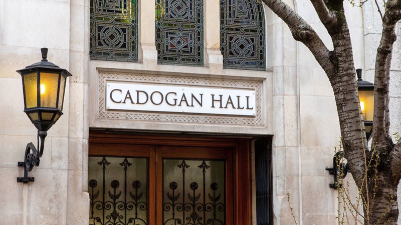 Watch an opera show in one of London's most historic venues. Credit: Shutterstock. Image courtesy of Shutterstock. A photo of the exterior of Cadogan Hall with the venue name placard and lamps on the building with a tree in the foreground