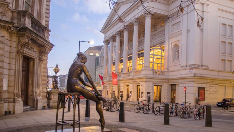 Look out for some of the best opera performances at the Royal Ballet and Opera in Covent Garden. Credit: Shutterstock. Image courtesy of Shutterstock. A photo of the exterior of the Royal Ballet and Opera House with the famous ballet statue and red flags hanging outside