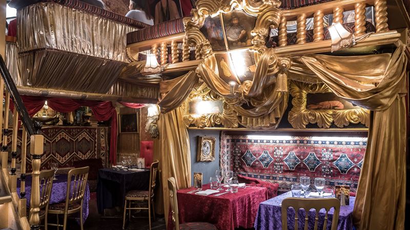 Experience live performances while you delight in a Turkish feast at Sarastro. Credit: Sarastro. Image courtesy of Sarastro. A photo of the interior of Sarastro restaurant with gold curtains framing the walls and decorated nooks to sit in
