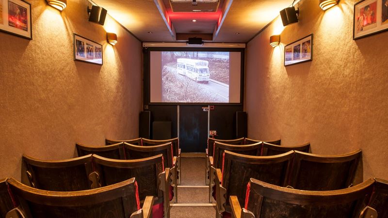 Enjoy independent, boundary-pushing short films at London Short Film Festival. Credit: Lauren Parsons Photography. Image courtesy of London Short Film Festival. interior shot of an old bus transformed into a cinema space with chairs and projector screen