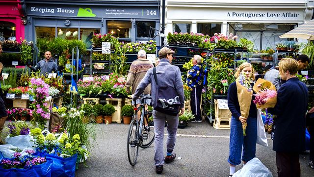 A man with a bicycle browses the flower-filled stalls of Columbia Road Flower Market