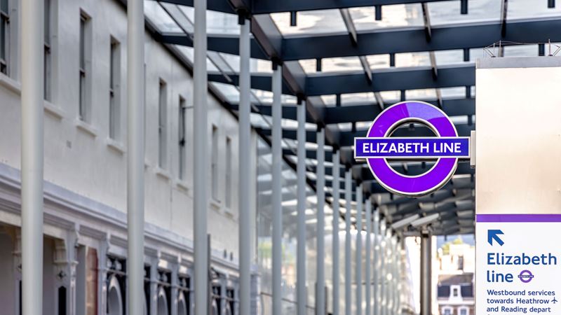 A photo of the purple Elizabeth line roundel in a London station 