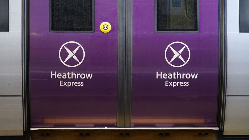 Book a smooth train journey between London with the Heathrow Express. Credit: Shutterstock. Image courtesy of Shutterstock. A photo of the purple train doors on the Heathrow Express with the logo on the side