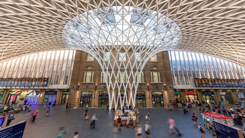 A photo of the Western Concourse at King's Cross Station with people walking around and into shops and eateries