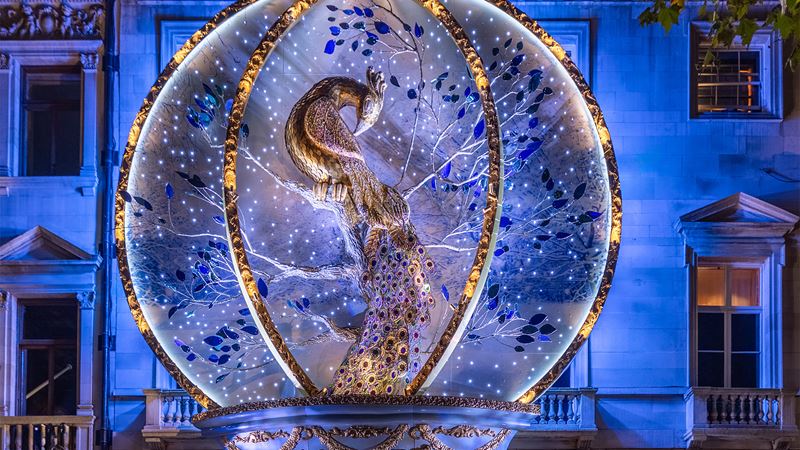 Admire the iconic Annabel's festive facade, in partnership with The Caring Family Foundation. Credit: Tom Chambers. Image courtesy of Annabel's. A festive facade featuring a giant golden peacock within a whimsical snow globe.
