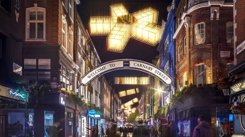 See an immersive display light up Carnaby. Credit: W Communications. Image courtesy of W Communications. Visitors wander underneath a lights display glowing above Carnaby