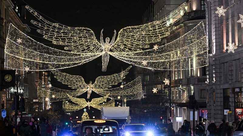 Visit the iconic Christmas lights that light up Regent Street annually. Credit: Jack Hall/PA Media Assignments. Image courtesy of Regent Street. A photo of the iconic Regent Street angels at night made up of lots of white Christmas lights hung above the road from buildings on either side with black taxis and cars below