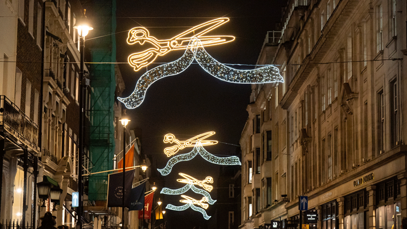 Be wowed by the twinkling Savile Row Christmas lights this Christmas. Credit: Aaron Chown/PA Wire. Image courtesy of Sister London. Giant gold shears light up Savile Row for Christmas.