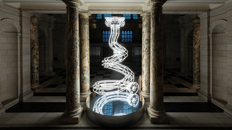 See the mesmerising Christmas tree installation at the V&A, each year designed by a different artist. Credit: Victoria and Albert Museum, London. Image courtesy of Victoria and Albert Museum, London. Image of the very top of the V&A Christmas tree touching the ceiling, featuring a swirly column design made from bright white LED lights