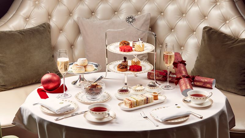 Delve into a mouthwatering festive afternoon tea at the Langham. Credit: Will Stanley Creative. Image courtesy of Sauce Communications. A festive round table with afternoon tea treats, Christmas decorations a glass of champagne