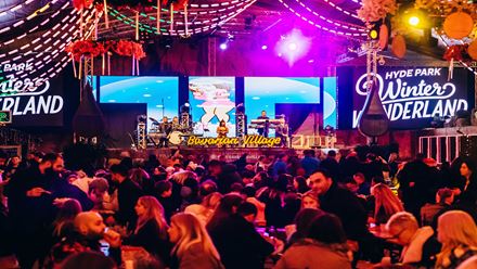 Visitors enjoy a drink and live music at the Bavarian Village at the Hyde Park Winter Wonderland in London. Image courtesy of Winter Wonderland. 
