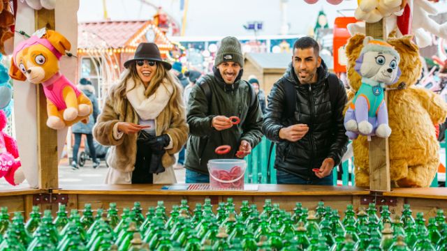 Take on the games at Winter Wonderland. Image courtesy of C. Faruolo/Winter Wonderland. Three people try to win a game of ring toss at winter wonderland in london.
