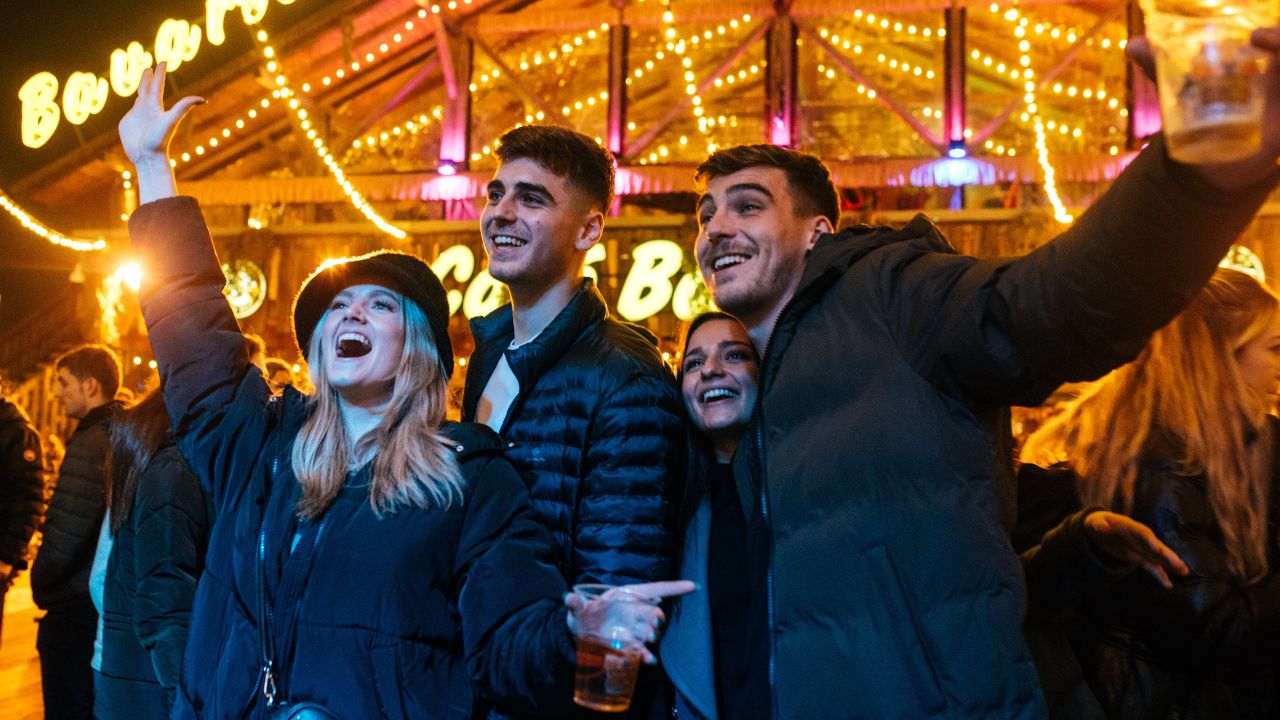Enjoy live music at Winter Wonderland. Image courtesy of Eric Ayden Barberini/Winter Wonderland. People cheer and dance by the bavarian bar at winter wonderland.