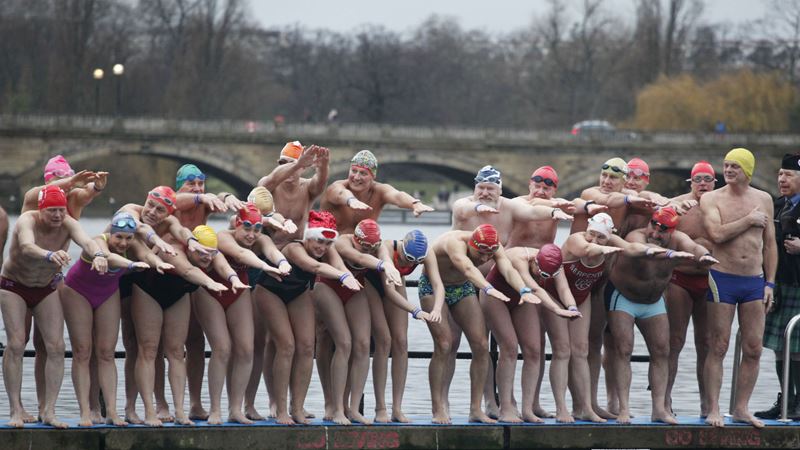 Swim in Serpentine Lido. where the annual Peter Pan Cup swim takes place. Credit: Serpentine Swimming Club. Image courtesy of Serpentine Swimming Club. People in their swimming costumes about to jump into the water during The Christmas Day Peter Pan Cup in Hyde Park.