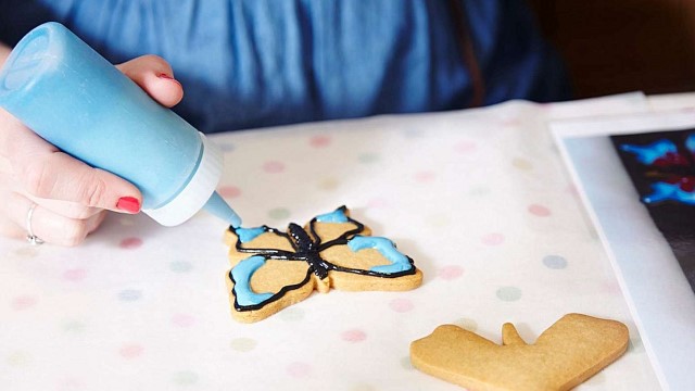 A person decorating a biscuit.