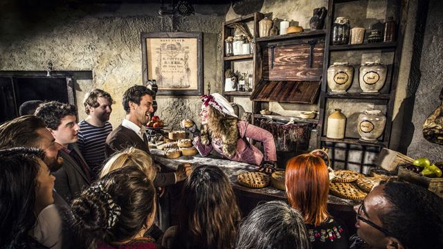 An actor playing Mrs Lovett, seemingly scary character, as people watch.