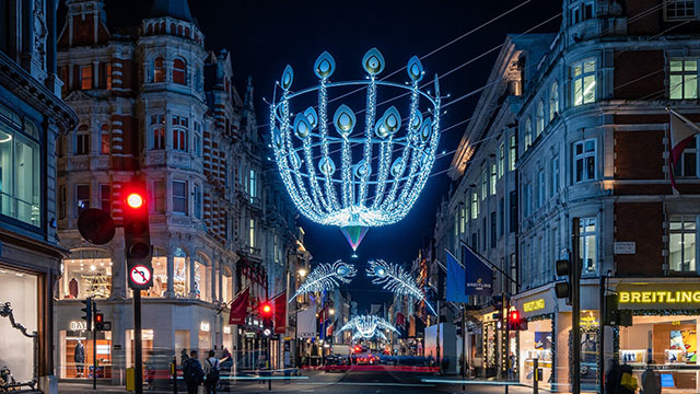 Shop luxury brands on Bond Street. ©Tareq Mooradun. A blue-lit Christmas light installation hanging above Bond Street by night.