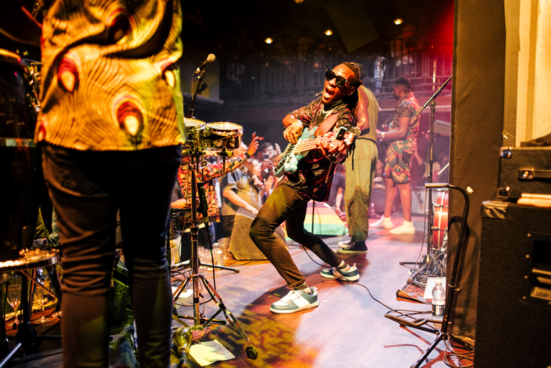 Jam out with world-class musicians at the intimate Jazz Cafe. Credit: Ben Mcquaide. Image courtesy of Jazz Cafe. Guitarist looks into camera next to rest of band with crowd in the background