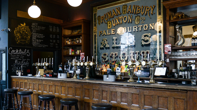 Take a seat and sip on craft beers at The Old Blue Last in east London. Credit: The Old Blue Last. Image courtesy of The Old Blue Last. Beer taps and bar stools line the bar at The Old Blue Last