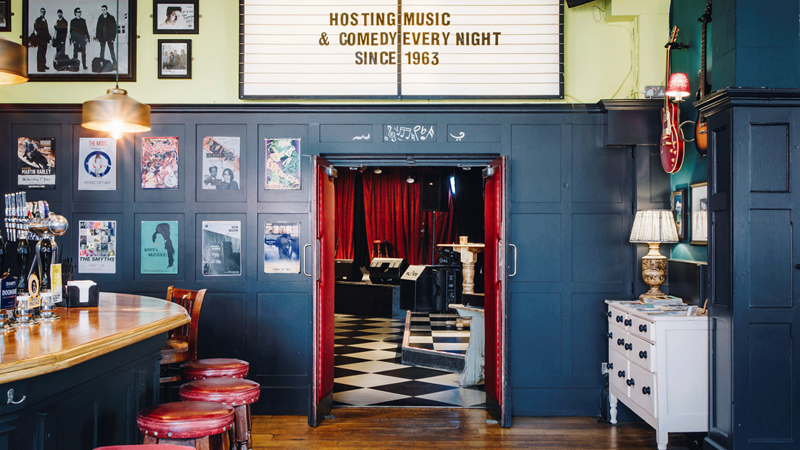 Find a variety of musical events at The Half Moon in Putney where U2, The Rolling Stones and The Who have all once played. Credit: Phil Atkinson. Image courtesy of The Half Moon. Doors open from the bar to the live music venue with sign overhead reading "Hosting music and comedy every night"