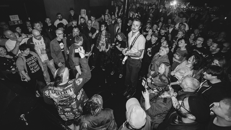 Join the energetic crowds that flock to The Lexington for live events from emerging talent. Credit: Jamie MacMillan. Image courtesy of The Lexington. A black and white image of a guitarist in the middle of a crowd at The Lexington
