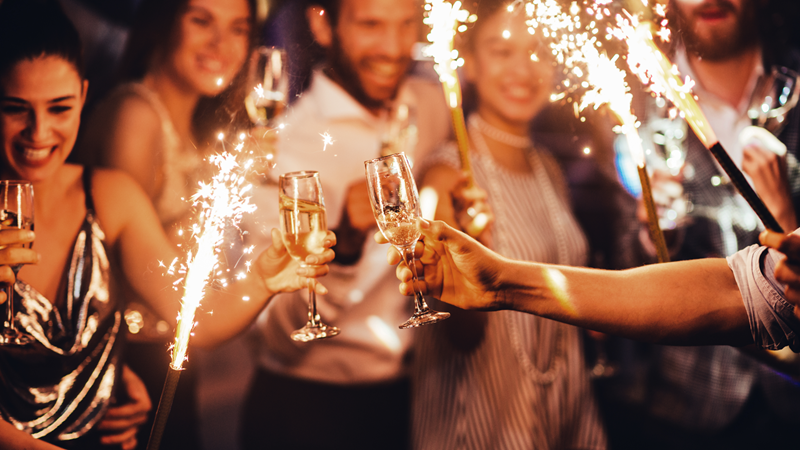 Friends celebrate the new year together with champagne and sparklers