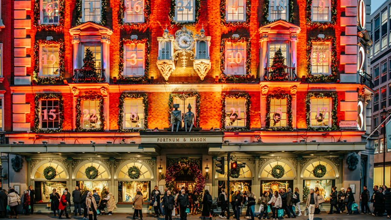 Admire the festive decorations adorning stores such as Fortnum & Mason around St James's and Piccadilly this Christmas. Credit: Michael Barrow/London & Partners. Image courtesy of London & Partners. Bright red and gold lights illuminate the front of Fortnum and Mason with each window representing an advent calendar door