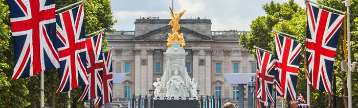 Union jack flags line the mall in front of buckingham palace.