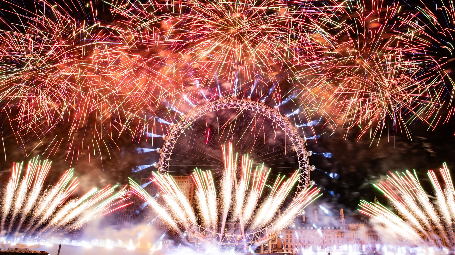 New Year's Eve fireworks display in London in 2024. Image courtesy of Greater London Authority. The London Eye surrounded by red fireworks on new years eve