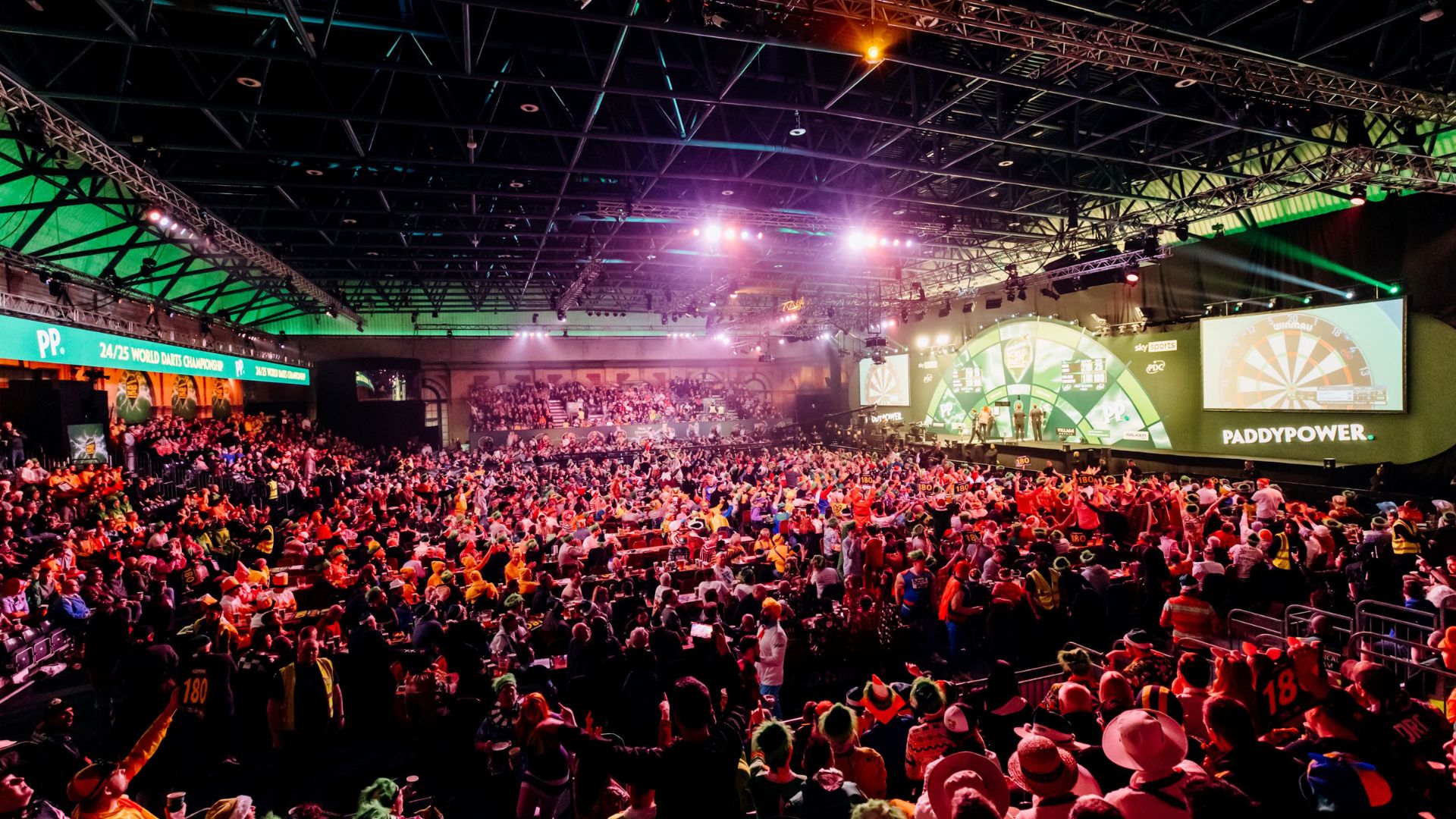 The world's best darts players go head to head at The O2 in London. Image courtesy of PDC. Photo Credit: Simon O'connor An audience of thousands of darts fans in front of the stage at alexandra palace in London