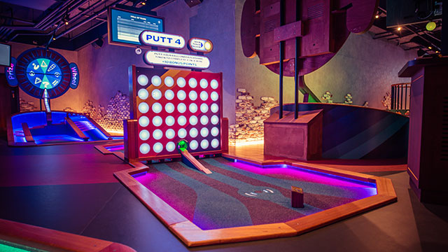 Navigate the tech-infused immersive courses at Puttshack. Image courtesy of Puttshack. A brightly coloured neon golf obstacle at Puttshack