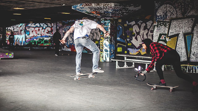 The iconic Southbank Skate Space © Samuel Regan Asante / Unsplash. Image courtesy of Samuel Regan Asante / Unsplash. Two skateboarders performing tricks in the iconic concrete and graffitied Southbank Skate Space in London.