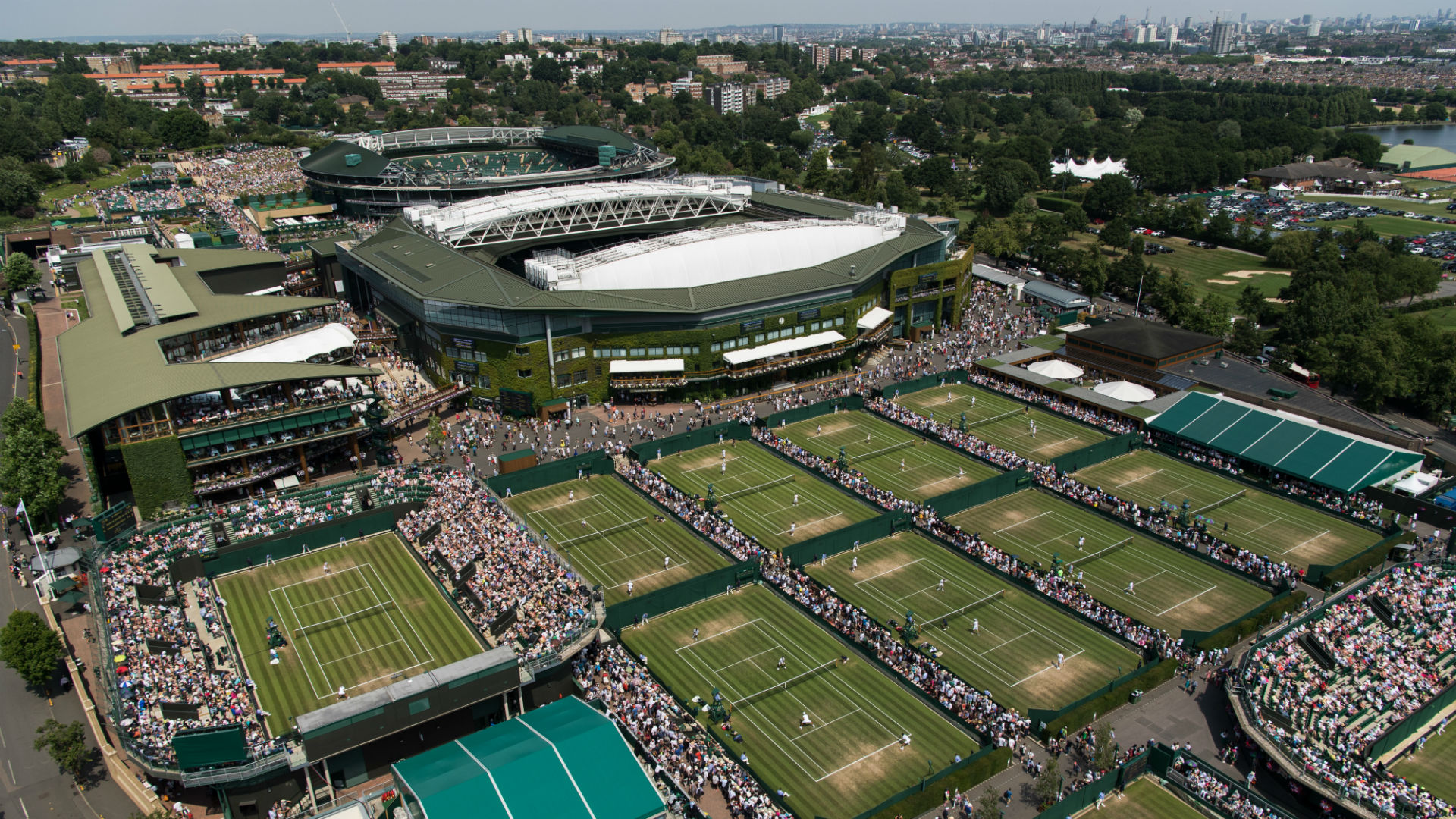 An aerial view of Wimbledonon the fourth day of play at The Championships 2017. Image courtesy of Wimbledon. An aerial view of the Grounds with the London skyline in the background on the fourth day of play at The Championships 2017 at The All England Lawn Tennis Club,