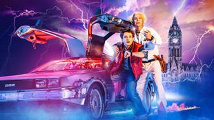 Marty McFly and Doc Brown stand next to their time-travelling DeLorean car as lightning flashes around them.