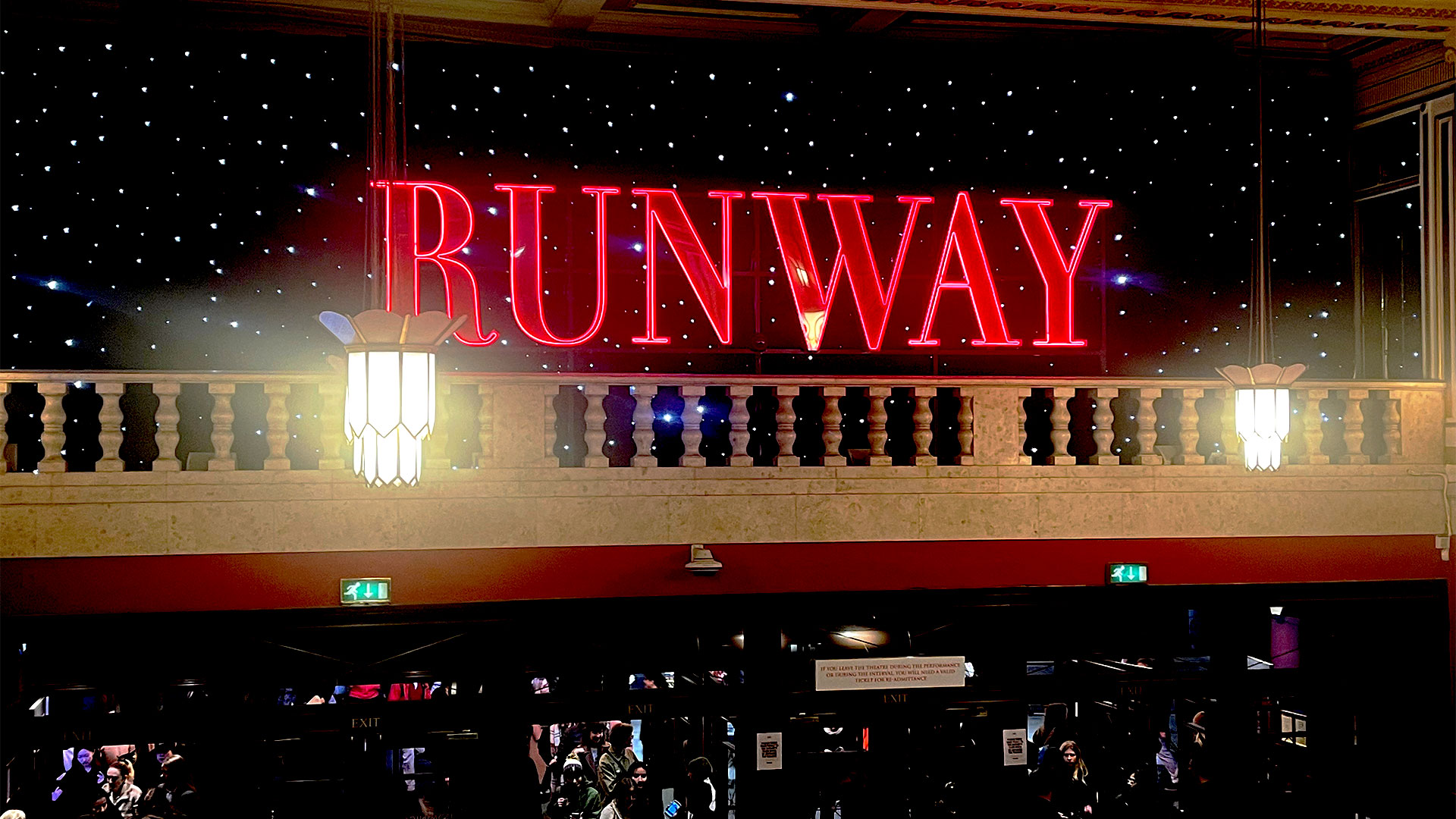 As you enter the Dominion Theatre, immerse yourself in high fashion and drama when seeing the Devil Wears Prada. Photo credit: Carole Rocton The bright, red, giant neon 'RUNAWAY' sign is perched inside the Dominion Theatre, immersing visitors in the world of The Devil Wears Prada.