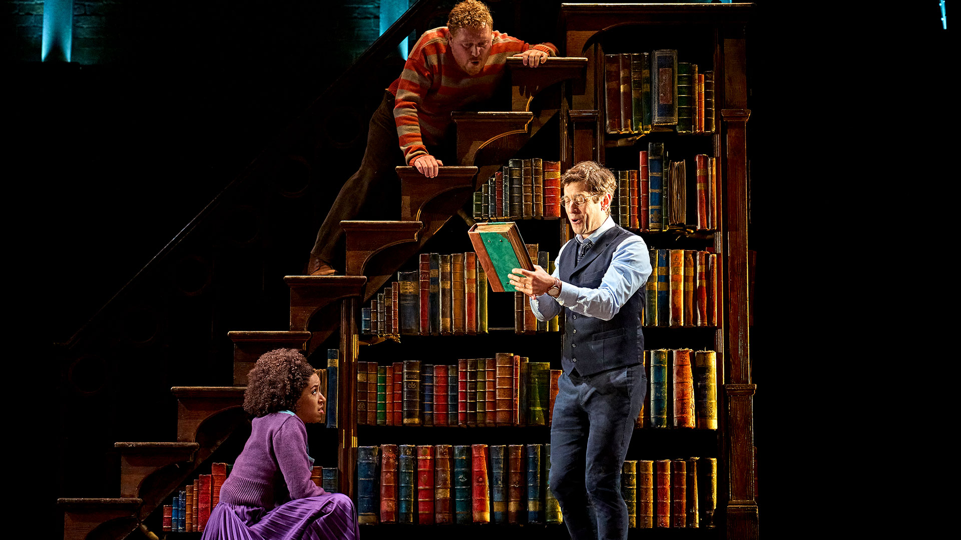 See magic unleashed in a new adventure with our favourite wizards in Harry Potter and the Cursed Child, currently at the Palace Theatre. ©London Theatre Direct Harry Potter and his two acolytes Ron and Hermione stands by a book shelf trying to solve a mystery.