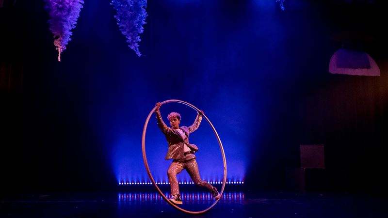 See a show at Jacksons Lane, one of London's leading venues for astonishing contemporary circus acts all year round. Image courtesy of Jacksons Lane. A man wearing a glittering golden suit with racing on stage aquipped with a hoola hoop.
